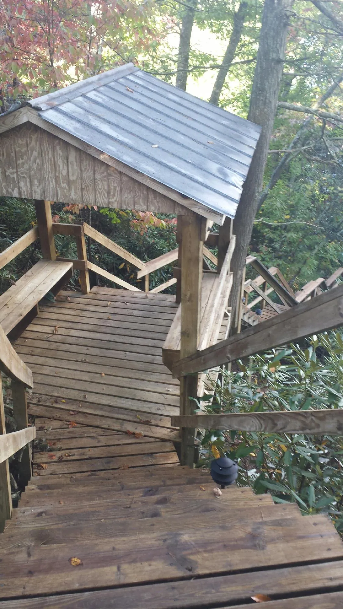 Metal roofed shelter over wooden steps on a wooded walkway — Skylight Repair & Installation work by our crew in Montclair